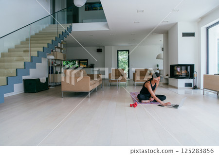 Young Beautiful Female Woman with Trainer via Video Call Conference in Bright Sunny House. Healthy Lifestyle, Wellbeing and Mindfulness Concept 125283856