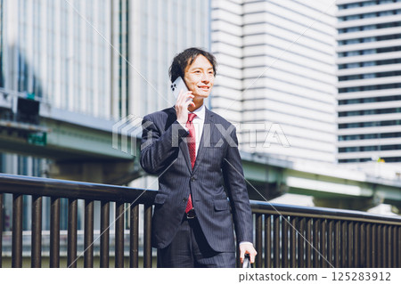 一名男子在辦公區使用智慧型手機 125283912