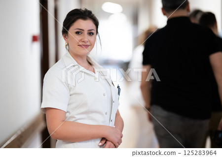 A tired nurse takes a quiet moment to rest in the hospital hallway, reflecting on a long and demanding shift. A tired nurse takes a quiet moment to rest in the hospital hallway, reflecting on a long and demanding shift. 125283964