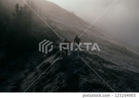 Trail running couple man and woman running on a mountain path 125284003