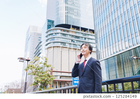 A man using a smartphone in an office district 125284149