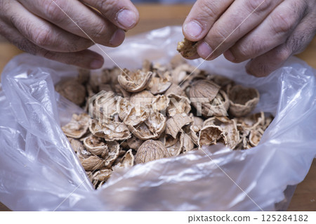 The man is cracking walnuts at home The man is cracking walnuts at home 125284182