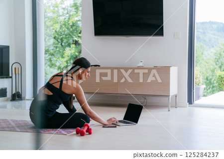 Young Beautiful Female Woman with Trainer via Video Call Conference in Bright Sunny House. Healthy Lifestyle, Wellbeing and Mindfulness Concept 125284237