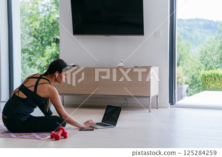 Young Beautiful Female Woman with Trainer via Video Call Conference in Bright Sunny House. Healthy Lifestyle, Wellbeing and Mindfulness Concept 125284259
