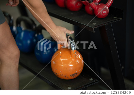 A close up shot of a man gripping dumbbells, ready to push through his intense workout in the gym, displaying focus, strength, and determination A close up shot of a man gripping dumbbells, ready to push through his intense workout in the gym, displaying focus, strength, and determination 125284269