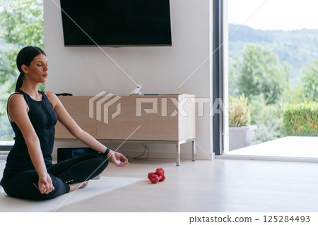 Young Beautiful Female Exercising, Stretching and Practising Yoga with Trainer via Video Call Conference in Bright Sunny House. Healthy Lifestyle, Wellbeing and Mindfulness Concept. Young Beautiful Female Exercising, Stretching and Practising Yoga with Trainer via Video Call Conference in Bright Sunny House. Healthy Lifestyle, Wellbeing and Mindfulness Concept. 125284493