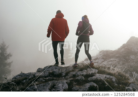 Trail running couple man and woman running on a mountain path 125284508