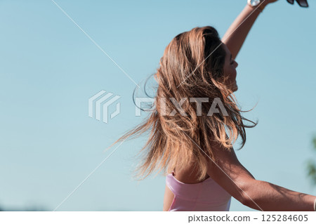 An elegant, stunning woman in a pink dress and sunglasses strikes a confident pose next to her electric scooter, radiating style and sophistication in the vibrant urban environment. An elegant, stunning woman in a pink dress and sunglasses strikes a confident pose next to her electric scooter, radiating style and sophistication in the vibrant urban environment. 125284605