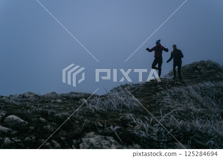 Trail running couple man and woman running on a mountain path 125284694