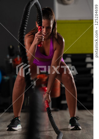 Fit Woman Performing Rope Conditioning Exercise in the Gym Fit Woman Performing Rope Conditioning Exercise in the Gym 125284699