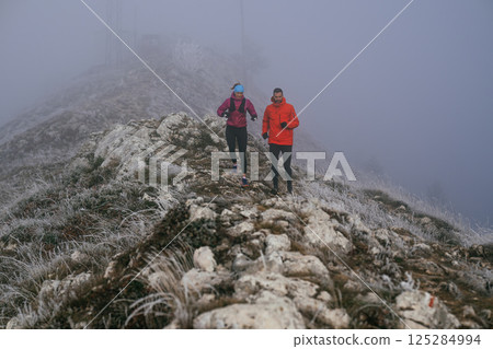 Trail running couple man and woman running on a mountain path 125284994