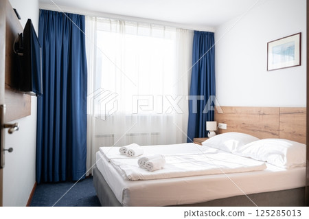 A modern and serene hotel room in a medical rehabilitation facility, designed for comfort and relaxation, offering a peaceful environment for patients to recover and rejuvenate 125285013