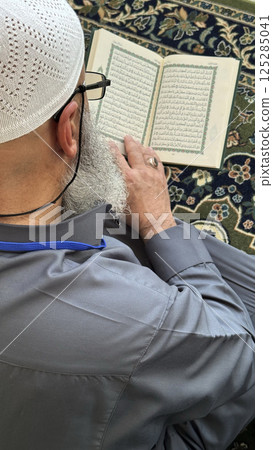 Mecca, Saudi Arabia - May 2, 2024: Young man, Hajj and Umrah pilgrim sitting and reading Quran in Masjidil Haram, Great Mosque in Makkah, Saudi Arabia. Hajj 2024. Mecca, Saudi Arabia - May 2, 2024: Young man, Hajj and Umrah pilgrim sitting and reading Quran in Masjidil Haram, Great Mosque in Makkah, Saudi Arabia. Hajj 2024. 125285041