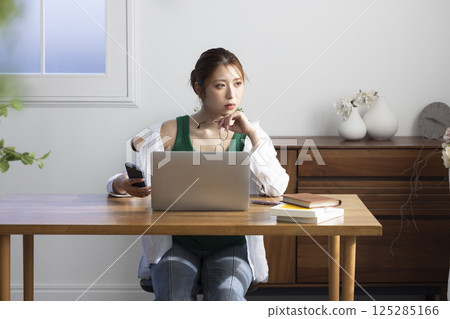 A woman using a computer in the living room 125285166