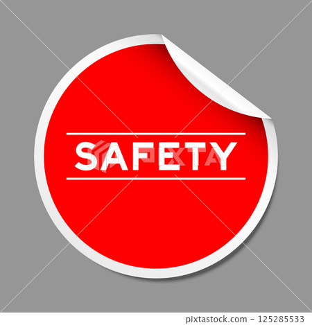 Red color peel sticker label with word safety on gray background 125285533