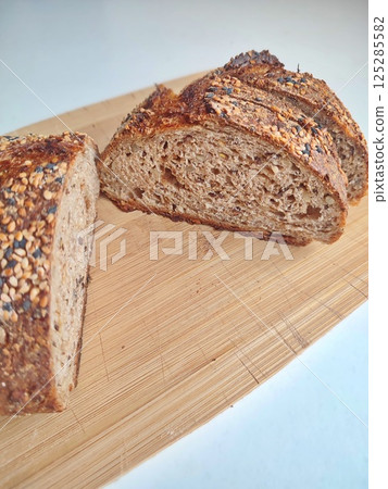 freshly cut artisanal sourdough bread showing crumb and texture on a rustic wooden surface 125285582