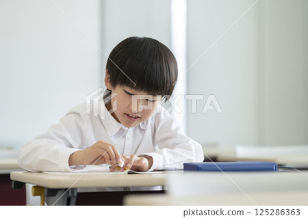 一名四年級男孩正在學習 125286363
