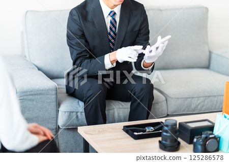 A businessman giving a quote and a housewife checking the amount, no faces A businessman giving a quote and a housewife checking the amount, no faces 125286578