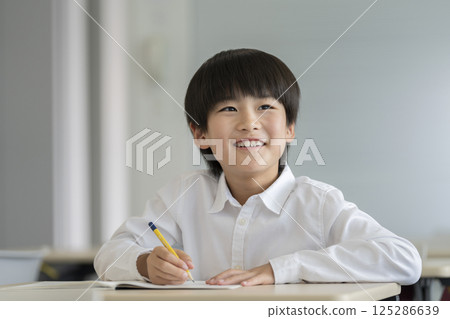 A fourth grade boy studying 125286639