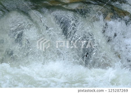 A close-up of the water flow of the Takano River swollen during the rainy season 125287269