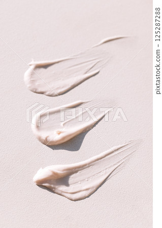 Close-up of the texture of pink cream on a light background. Moisturizing serum is smeared on the backdrop Close-up of the texture of pink cream on a light background. Moisturizing serum is smeared on the backdrop 125287288