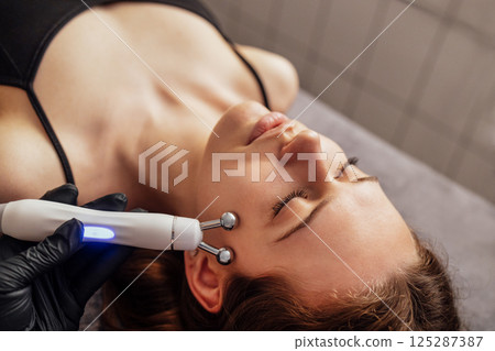 Microcurrent medicine treatment. Portrait of beautiful woman. 125287387