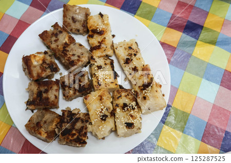 Chinese Cantonese style turnip cake and yam cake pudding cut in small pieces for Chinese new year 125287525