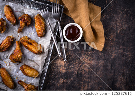 Baked spicy chicken wings with sauce 125287615