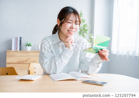 A woman holding a household account book A woman holding a household account book 125287794