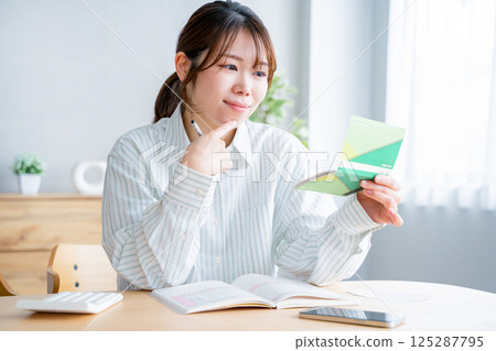 A woman holding a household account book A woman holding a household account book 125287795