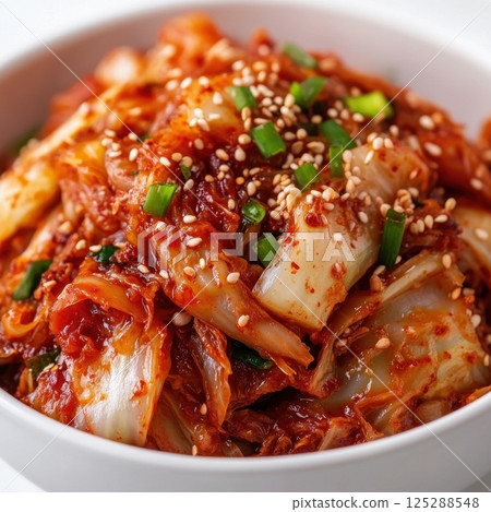Spicy korean kimchi with sesame seeds and green onions in white bowl 125288548