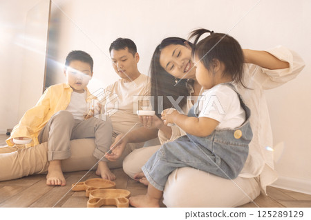 A happy Asian family. Korean parents and their cute little children play with toys at home A happy Asian family. Korean parents and their cute little children play with toys at home 125289129