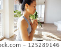 Asian woman has closed her eyes and is sitting in lotus position 125289146