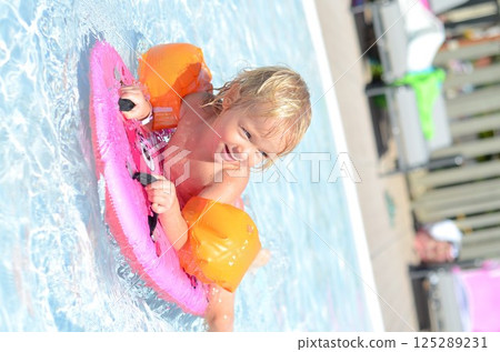 Child Enjoying Pool with Float and Water Wings 125289231