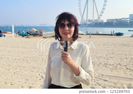 News from the city beach, TV presenter films a story about vacation News from the city beach, TV presenter films a story about vacation 125289703