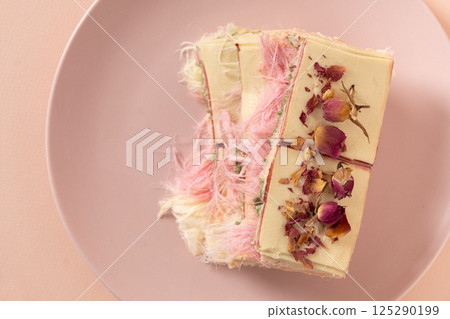 Trendy pink chocolate with airy filling on marble board. Tasty dessert. 125290199