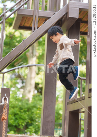 5歲男孩從遊樂場設備上跳下 125290533