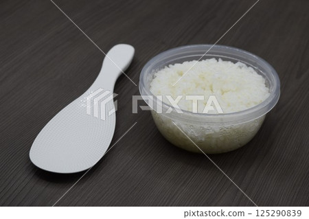 Rice scoop and white rice in a storage container Rice scoop and white rice in a storage container 125290839