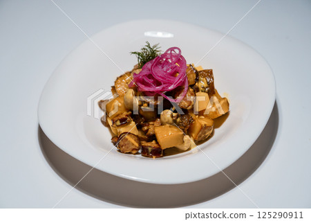 Gourmet salad with roasted vegetables, mushrooms and pickled onions served on white plate against bright background Gourmet salad with roasted vegetables, mushrooms and pickled onions served on white plate against bright background 125290911