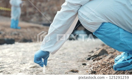 Ecologist sampling water from the river with test tube, Biologist wear protective suit and mask collects sample of waste water from industrial, problem environment, scientist environmentalist 125291259