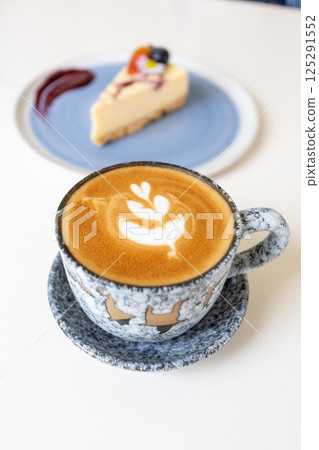 Close up shot of hot coffee latte art on wood table in cafe Close up shot of hot coffee latte art on wood table in cafe 125291552