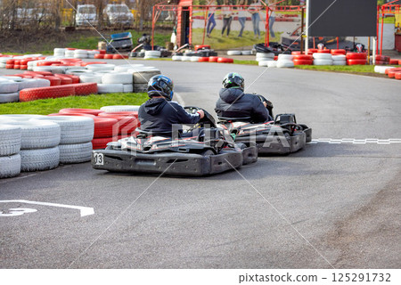 Exciting kart racing competition unfolds on a vibrant outdoor track in springtime Exciting kart racing competition unfolds on a vibrant outdoor track in springtime 125291732