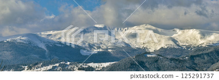 Winter landscape with high mountain hills covered with evergreen pine forest after heavy snowfall on cold wintry day. Winter landscape with high mountain hills covered with evergreen pine forest after heavy snowfall on cold wintry day. 125291737