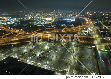 View from above of many parked cars on illuminaded parking lot at night in front of a superstore. Place for vehicles in front of a shopping mall center 125291766