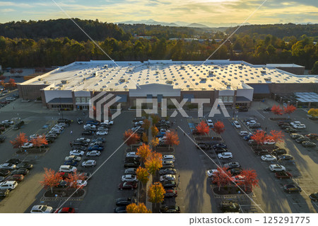 View from above of american grocery store with many parked cars on parking lot with lines and markings for parking places and directions. Place for vehicles in front of a strip mall center View from above of american grocery store with many parked cars on parking lot with lines and markings for parking places and directions. Place for vehicles in front of a strip mall center 125291775