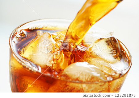 Iced coffee being poured vigorously into a glass Iced coffee being poured vigorously into a glass 125291873