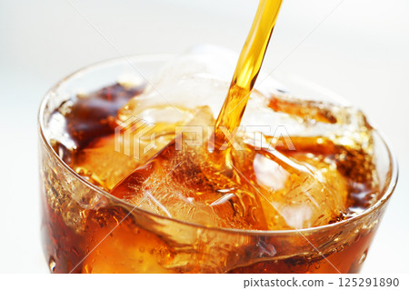 Iced coffee being poured vigorously into a glass Iced coffee being poured vigorously into a glass 125291890