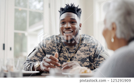 Young african american soldier smiling at elderly woman in cozy home setting 125291909