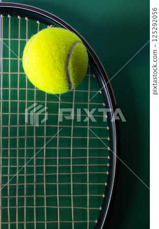 Top view of tennis ball on racket on green background. Concept of sports competitions 125292056