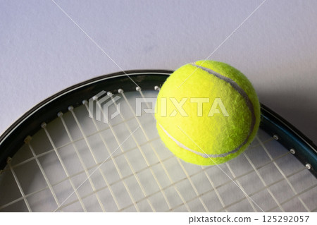 Horizontal picture of a tennis ball on a reaquet. Light background. Copy space 125292057
